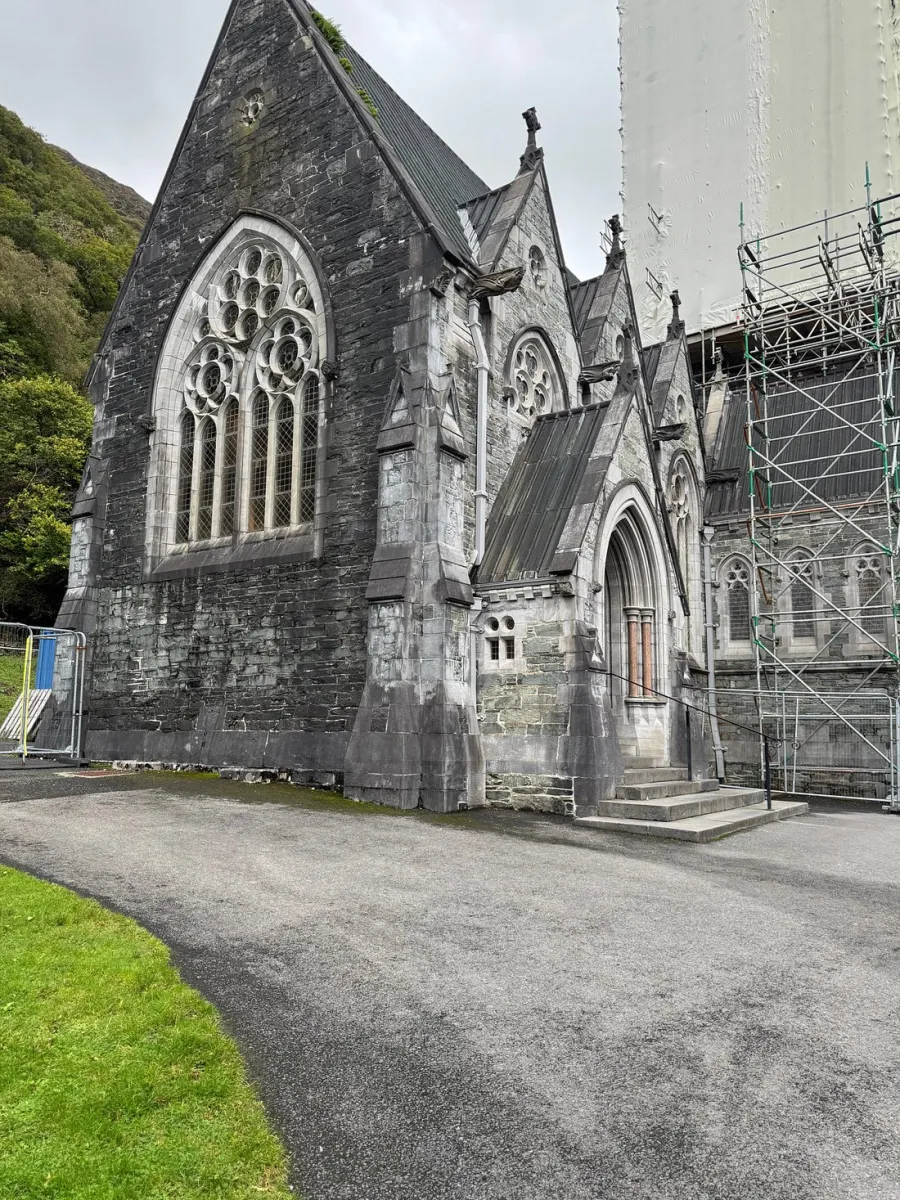 Gothic-style stone church with scaffolding.