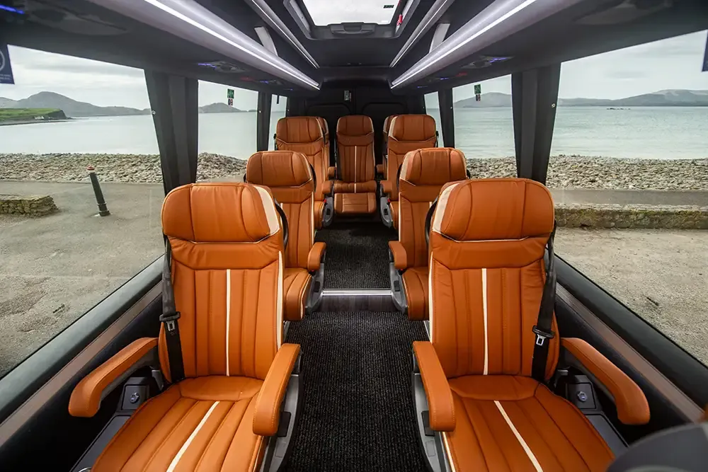 Interior of a luxury minibus with leather seats.