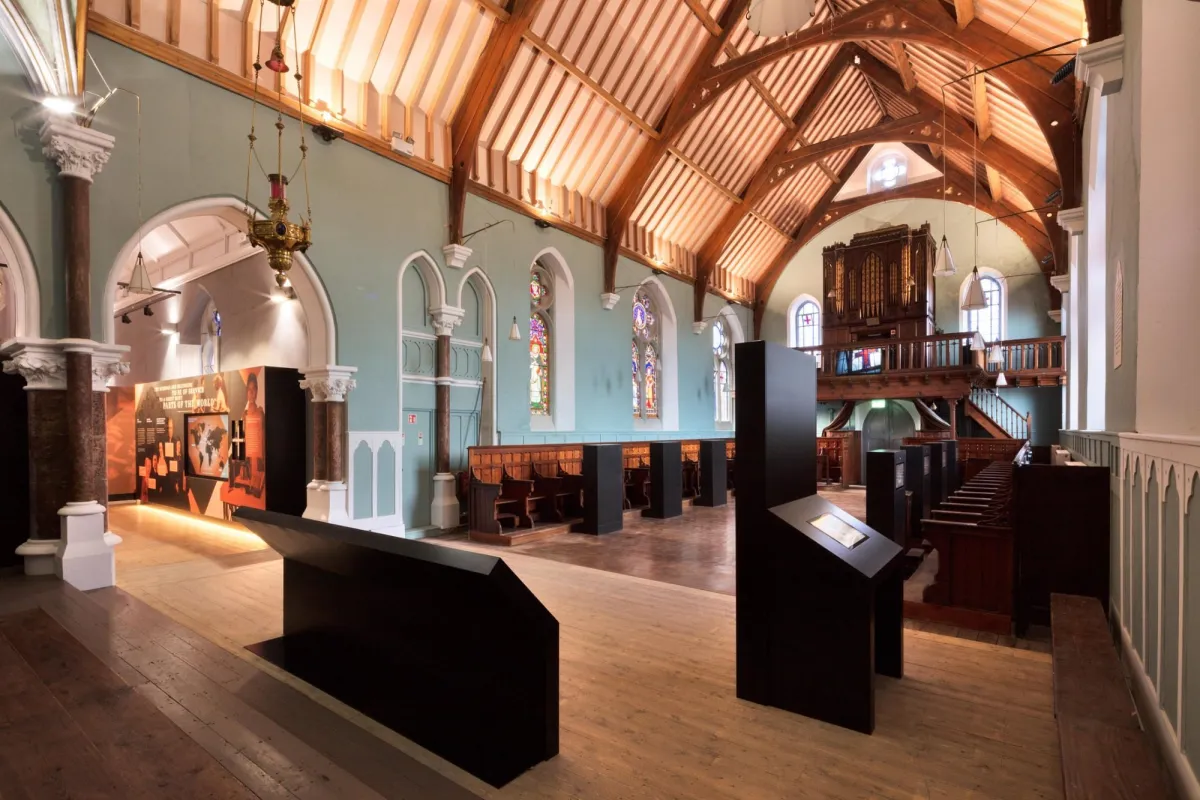 Interior of a historic church with wooden beams and stained glass.