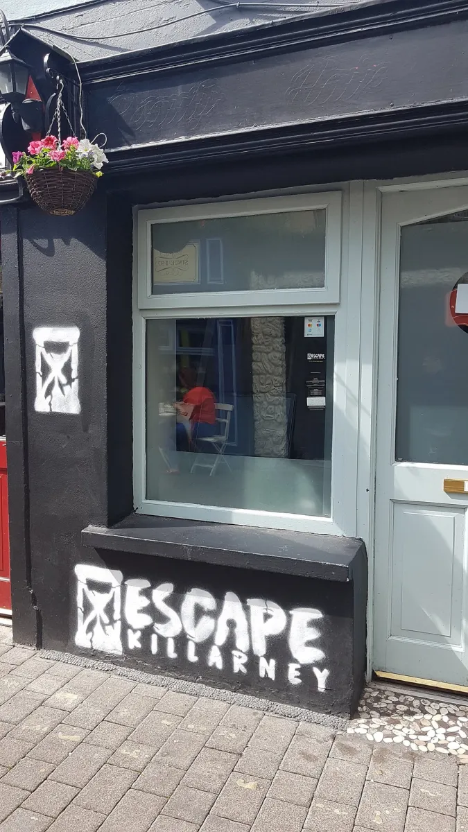 Shopfront with 'Escape Killarney' painted on wall.