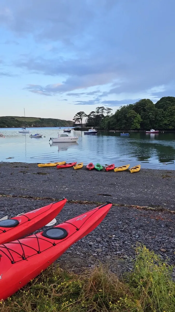 Atlantic Sea Kayaking recreation base in Cork, red kayaks on shore