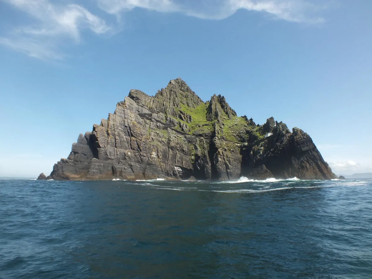 Rocky island with green patches in the ocean