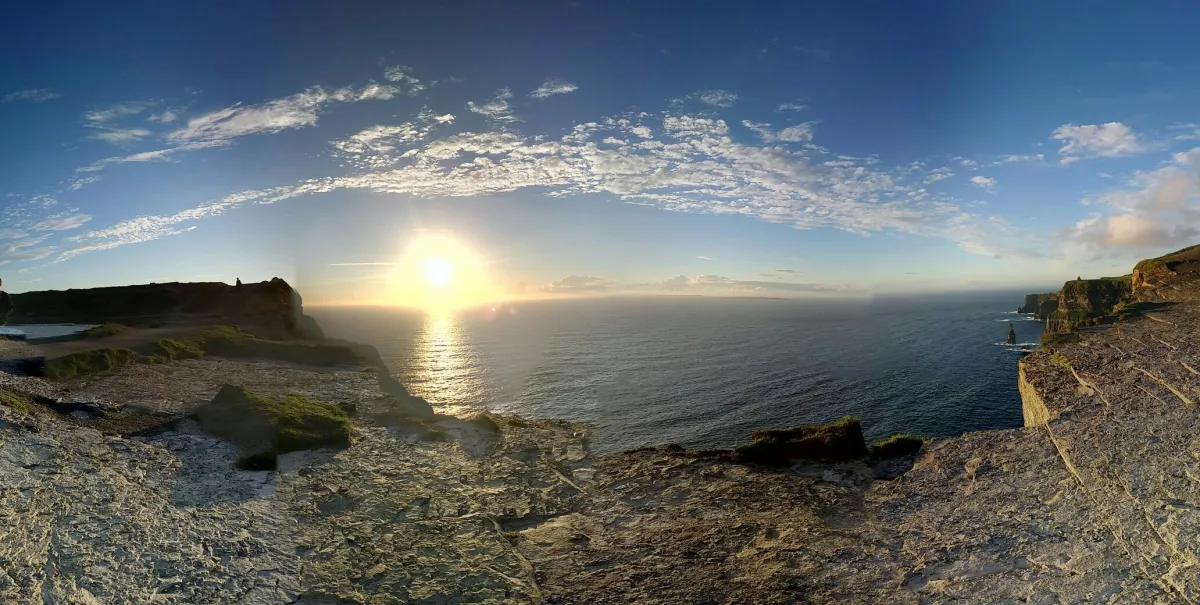 Sunset over ocean cliffs with clear sky