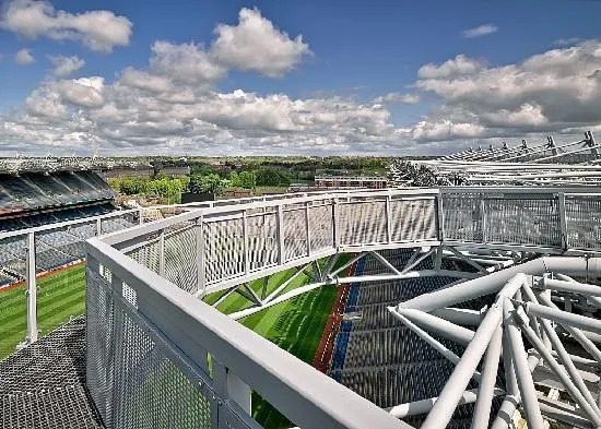 View from stadium roof with metal structures and clouds.