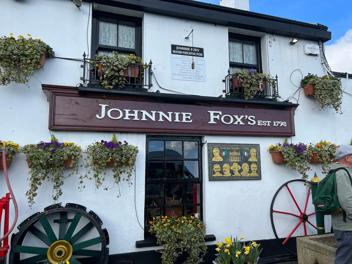 Exterior of Johnnie Fox's pub with flowers and signage.