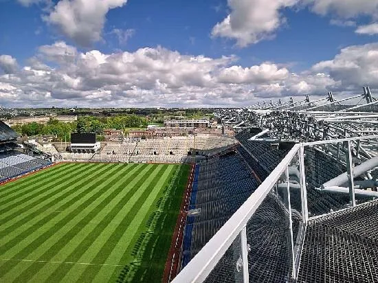 Aerial view of a large empty stadium with green field.