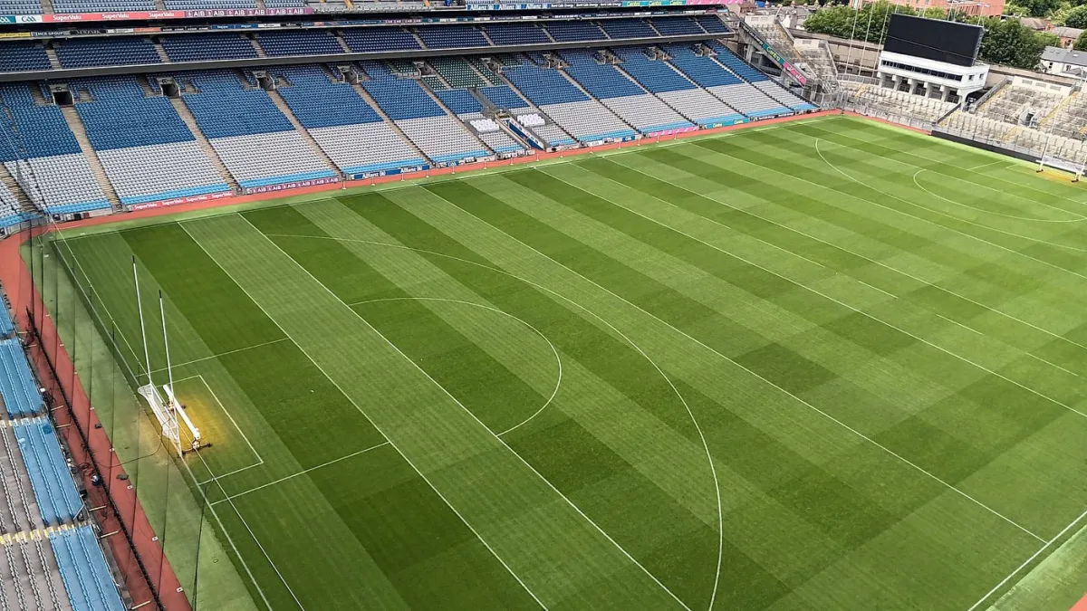 Empty sports stadium with green field and seating.
