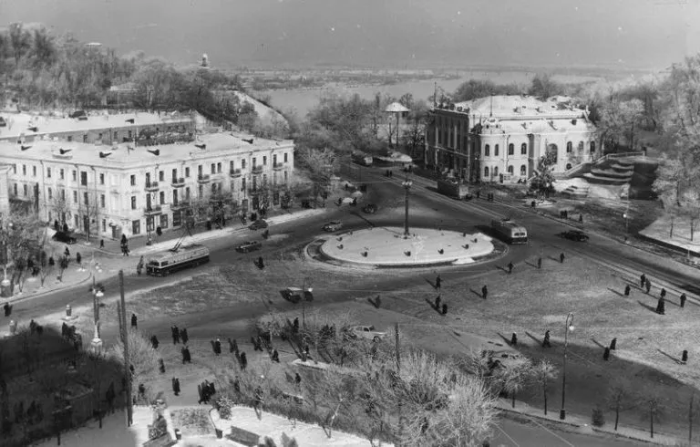 Історична площа з будівлями і круговим рухом.