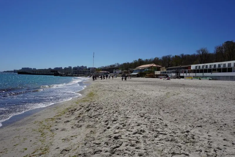Пляж з людьми та будівлями на горизонті