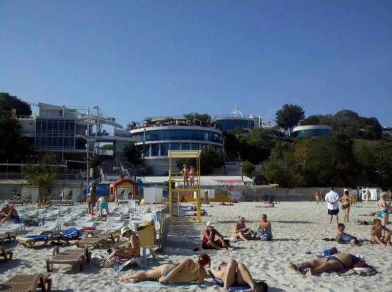 Пляж з відпочивальниками та будівлями на тлі