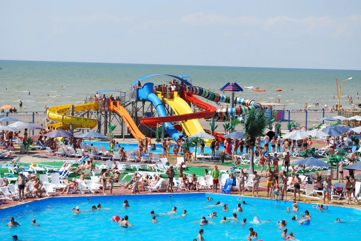 Водний парк з басейном і гірками біля моря.