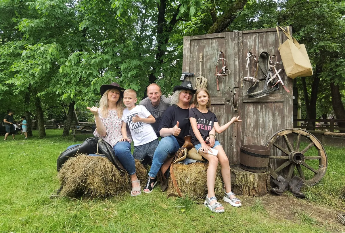 Група людей сидить на сіні на природі.
