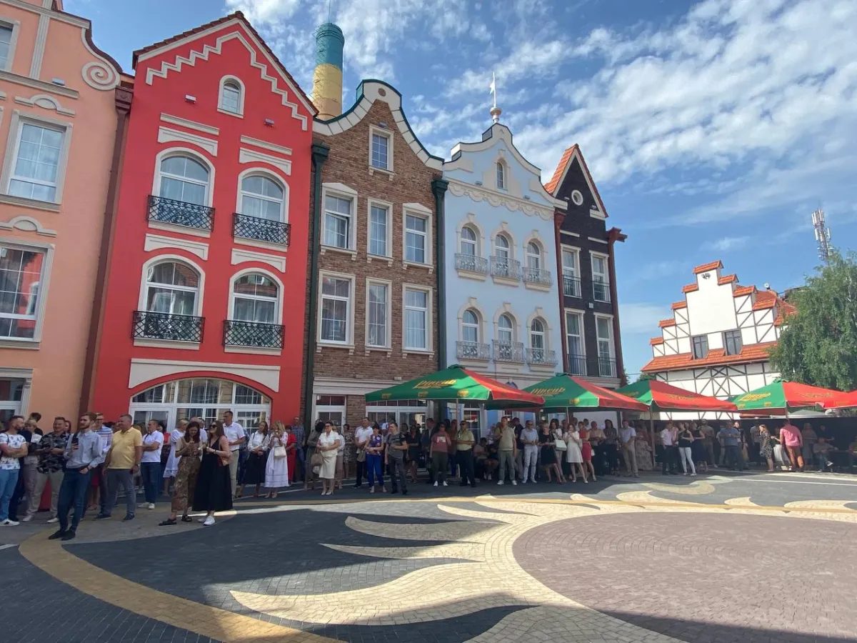 People gathered in front of colorful buildings