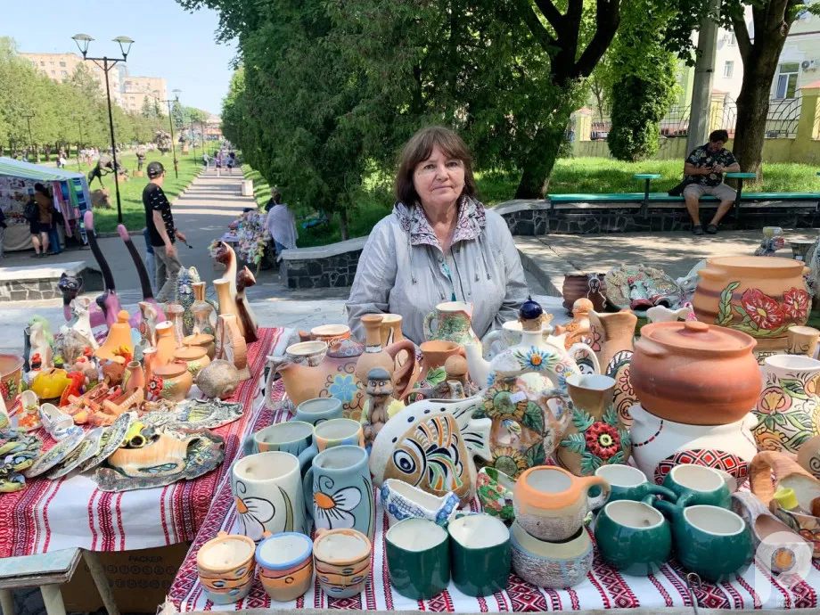 Жінка на ярмарку з керамічними виробами.