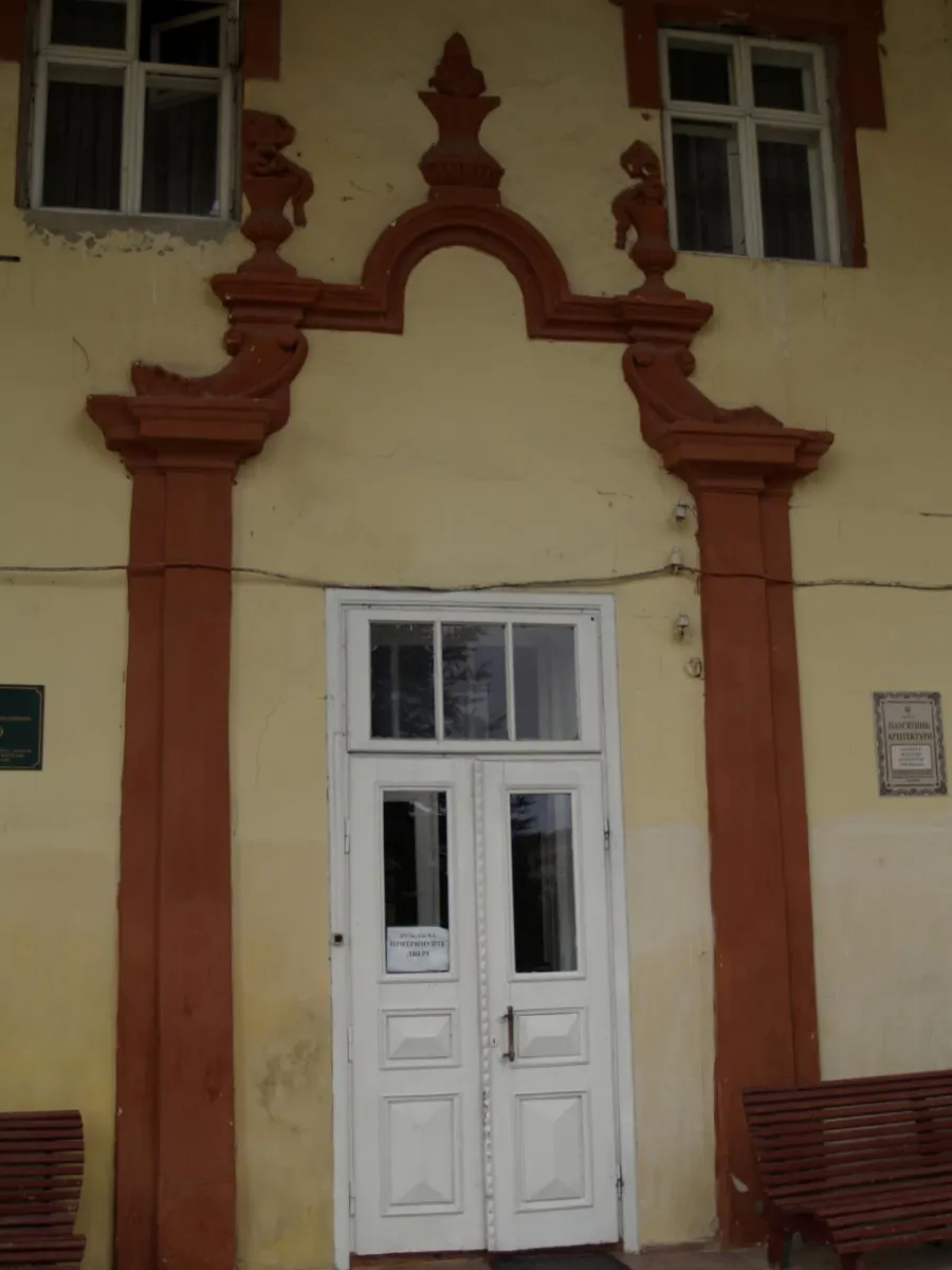 Стара будівля з білими дверима та вікнами
