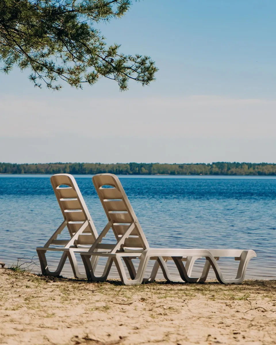 Шезлонги на піщаному пляжі Білого озера біля бази відпочинку White Lakee для релаксу на сонці