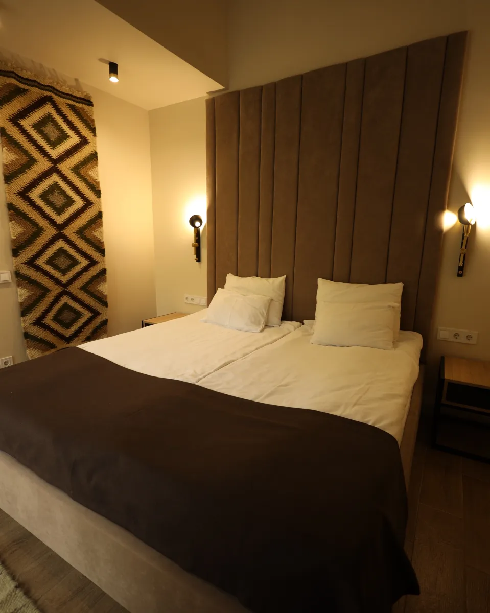 Дерев'яні картини ручної роботи у етно-стилі над сірим диваном у River Rest.