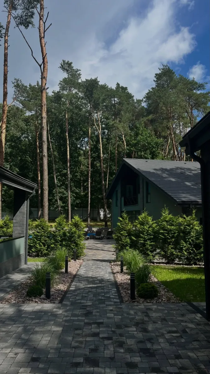 Доріжка з бруківки серед зелених насаджень і сосен на території комплексу «Стариця»