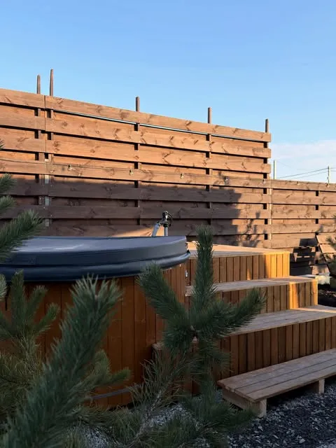Дерев'яний чан на терасі поруч із дерев'яною огорожею на базі відпочинку «Чебрець».