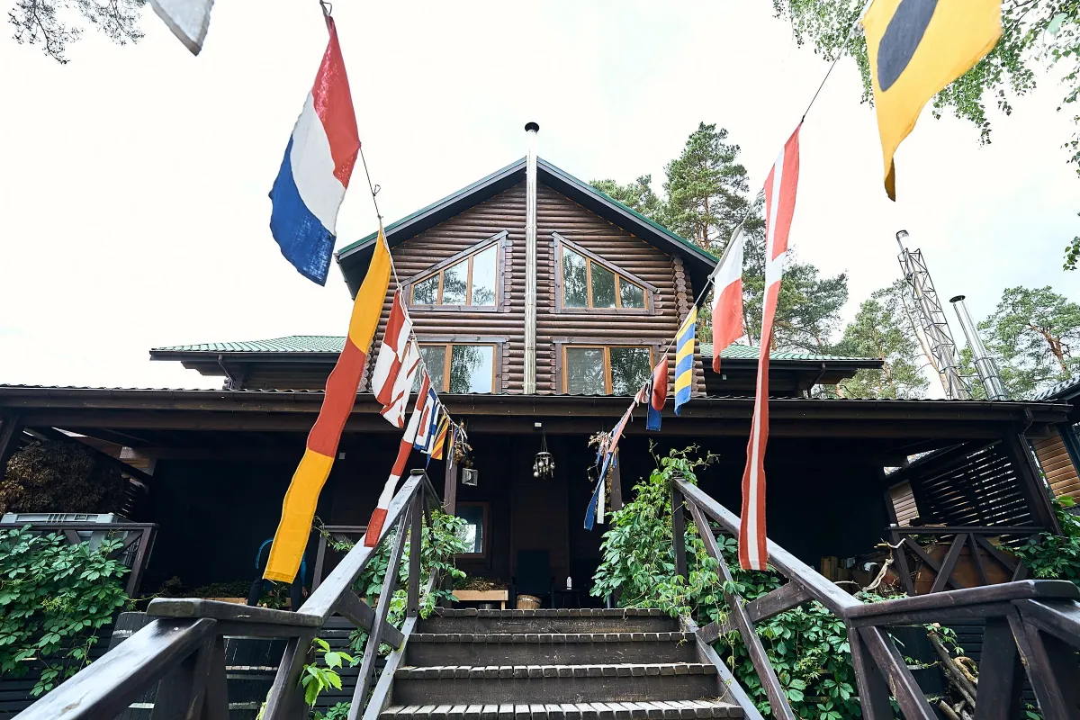 Фасад дерев'яного котеджу SPA Chalet на курорті Zaliv, прикрашений декоративними прапорцями.