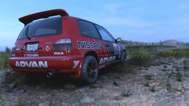 1990 Nissan Pulsar GTI-R hatchback with offroad tires, a tray spoiler, and a black-and-red-striped Advan livery sitting in a rocky field with low-growing green plants at sunset.