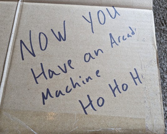 Writing on a box reads, "Now you have an arcade machine. Ho ho ho."