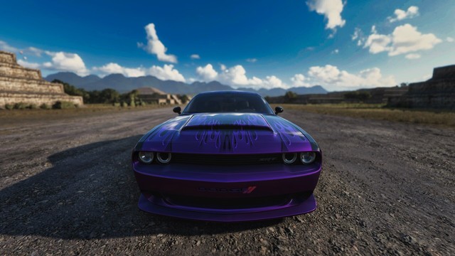 Capture of the front bumper, hood, and windshield of a  black Dodge Challenger SRT Demon with purple two-tone flames from a wide angle creating a fish-eye look with clouds and a sky in the background.