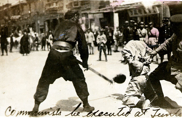 Public beheading of a communist in a Shanghai street, with numerous onlookers. By Unknown photographer - ru:Файл:Shanghai massacre 1927 2.jpg uploaded by ru:Участник:Nut1917 (Russian Wikipedia), 杀害共产党人情景, Public Domain, https://commons.wikimedia.org/w/index.php?curid=34985399