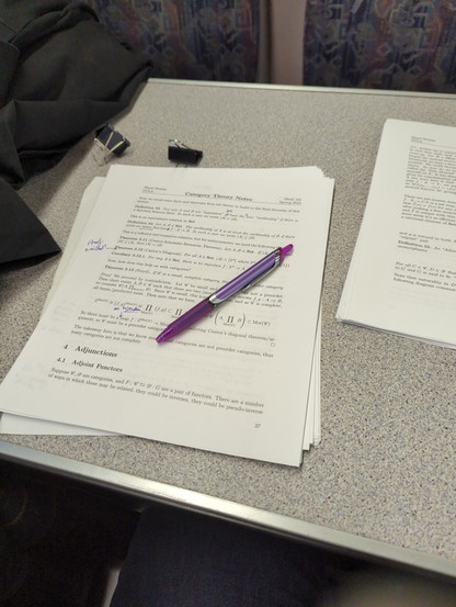 A picture of a traincar table with some notes under a purple pen.