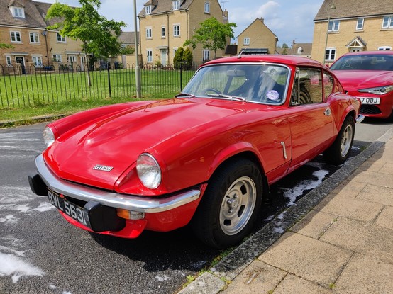 The same red Triumph GT6 sitting by the roadside now clean of foam and looking rather smart (if you don't get too close)