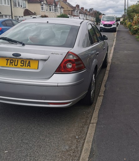 Rear 3 /4 view of a Silver Ford Mondeo Ghia X parked ina suburban street.