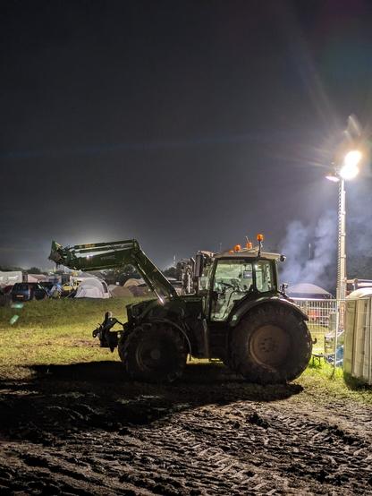 Trecker in der Nacht unter einem Flutlicht
