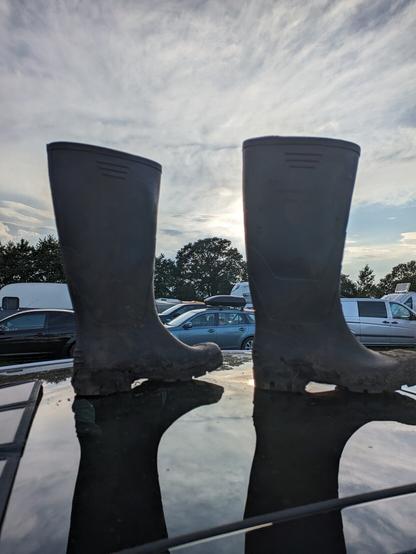 2 Gummistiefel im Sonnenuntergang auf einem spiegelnden Autodach