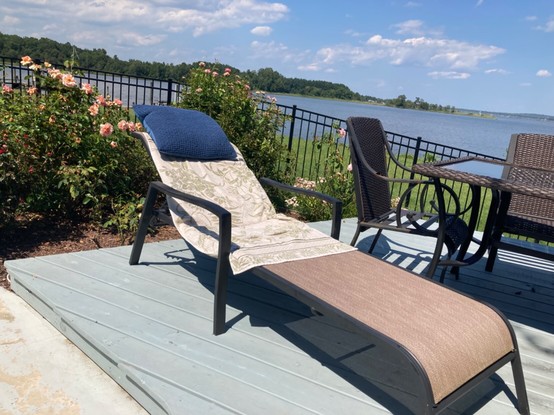 A lounge chair set up in the sun, with the Chesapeake Bay in the background.