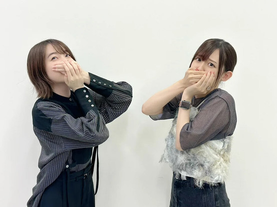 Reina and Rie with both hands covering mouth, conveying something funny.