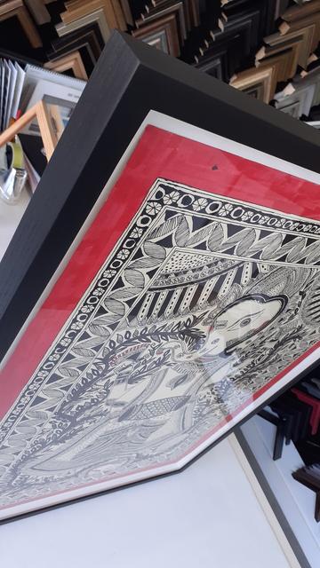 Framed artwork from am angle showing the corner of the frame.