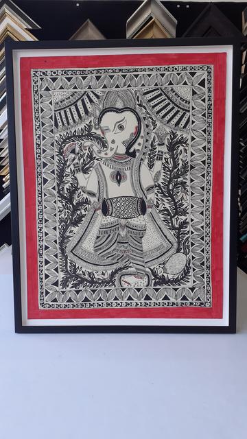 Indian folk art framed. The artwork is ink on paper depicting the god Ganesha with a mouse companion. Around him are plants and leaves and a decorative border surrounds the whole thing.