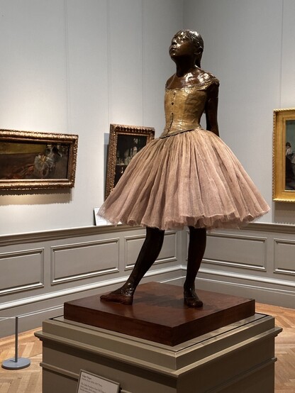 A sculpture in the round of a young girl dressed as a ballerina