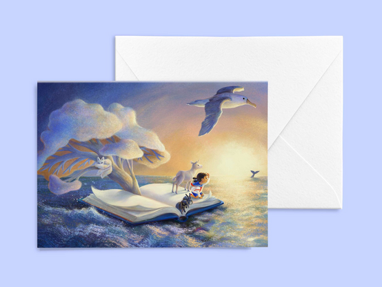 A mockup photo of a greeting card and an envelope. The illustration features a girl, two bunnies and a unicorn looking out on the sea towards a whale in far distance from an open book they’re sailing as a boat. There’s a pale tree growing from the gutter of the book and a three-tailed fox is sleeping on it. An albatross is guiding them overhead.