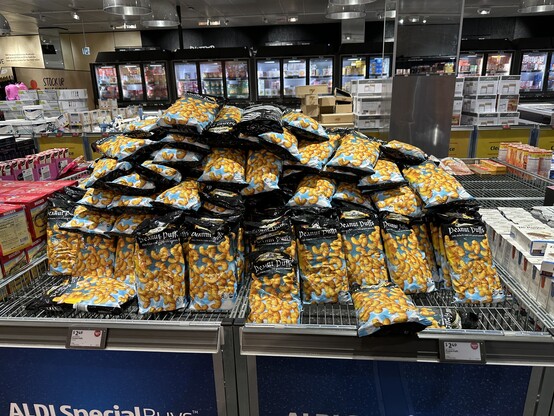 A huge pile of Peanut Puff chips piled on top of each other in a middle aisle bin at my local ALDI store.