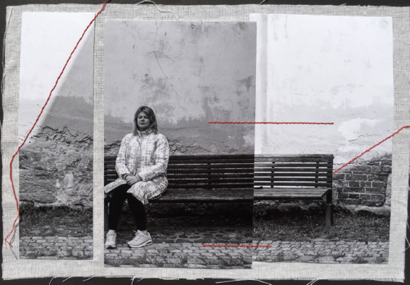 Foto einer Collage, die auf Stoff ist. Darüber  ist ein zerschnittenes Foto in verschiedene Grautönen, verbunden mit einzelnen roten Stofflinien. auf dem Foto ist eine Frau auf einer Bank sitzend.