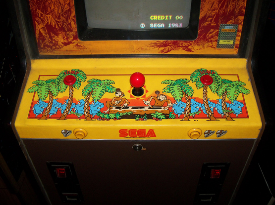 A close-up of the control area for "Congo Bongo". It has an illustration two monkeys playing xylophone as blue rhinos dance it up nearby, against a yellow background.