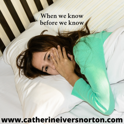 A shy smiling woman in bed. The caption reads, "When we know before we know."