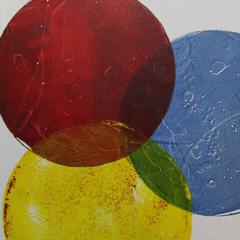 Three round shapes in primary colors -red, blue, yellow - printed somewhat overlapping on white paper. Each disk-shape has a bit of texture from brayer marks or the color use prior.