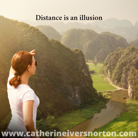 A woman with a hand shielding her eyes from the sun looks across a river valley. The caption reads, "Distance is an illusion."