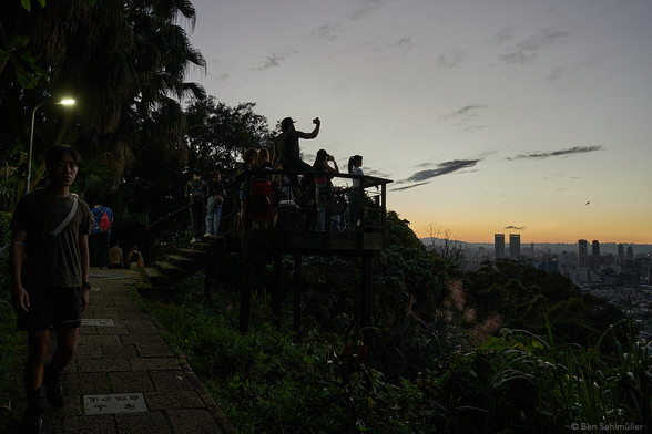 A group of photographers and nightly wanderers on a platform overlooking Taipei