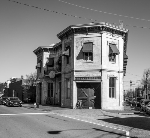 Black and white photo of an old fire station on a corner. It's a two story, triangular shaped, Italianate style building built in 1883.