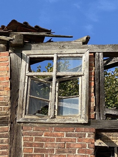 Stark beschÃ¤digtes Fenster in den Resten einer Fachwerkhaus-Fassade