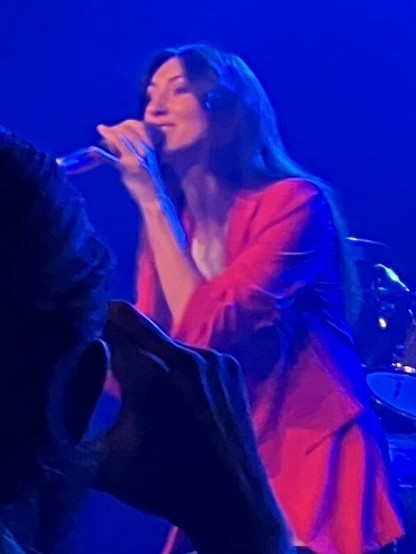 A female singer in a red jacket.