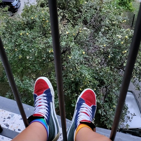 Chilling on a balcony with my feet through the rails, underneath is a quince tree